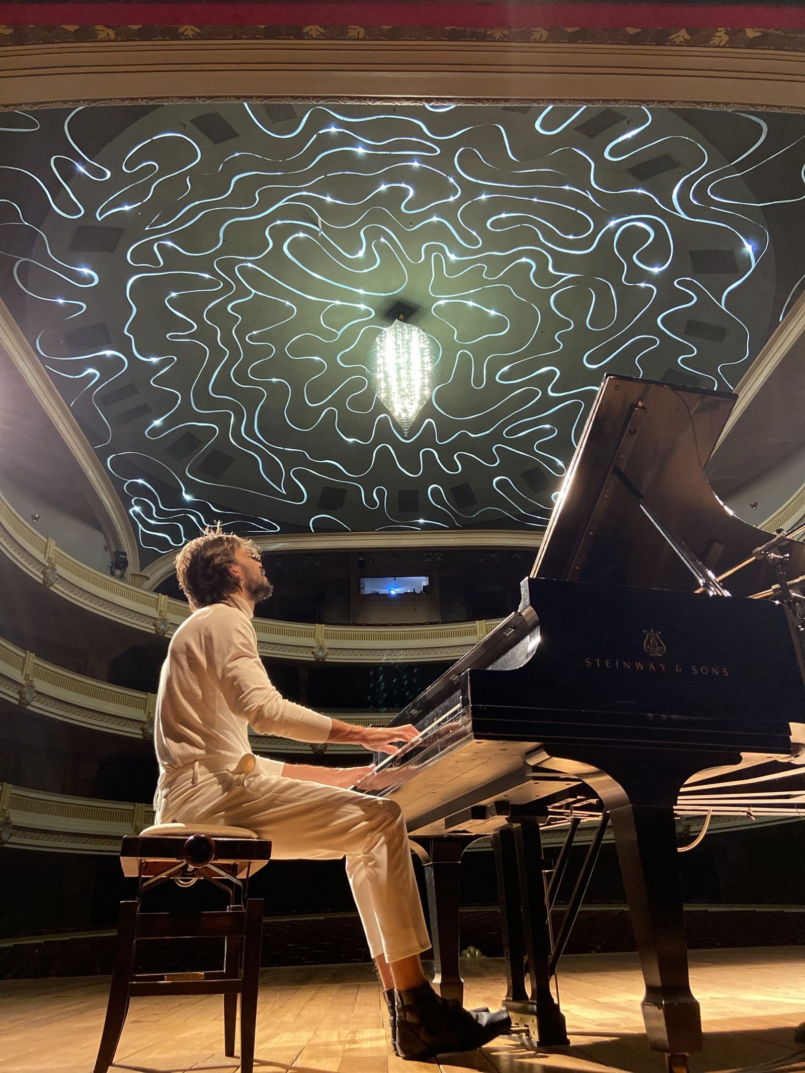Salomão Soares at the Steinway piano on the stage of Theatro Pedro II, beneath the theater’s ceiling