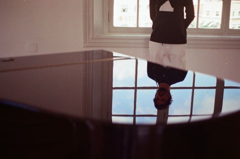 Salomão Soares reflected in the piano lid