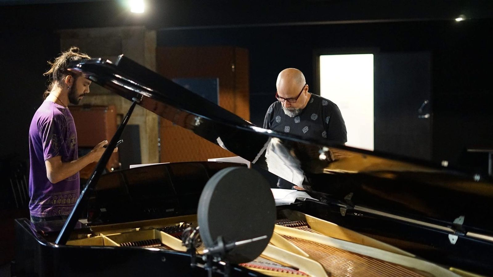 Toninho Ferragutti and Salomão Soares reading scores at the piano, in the studio