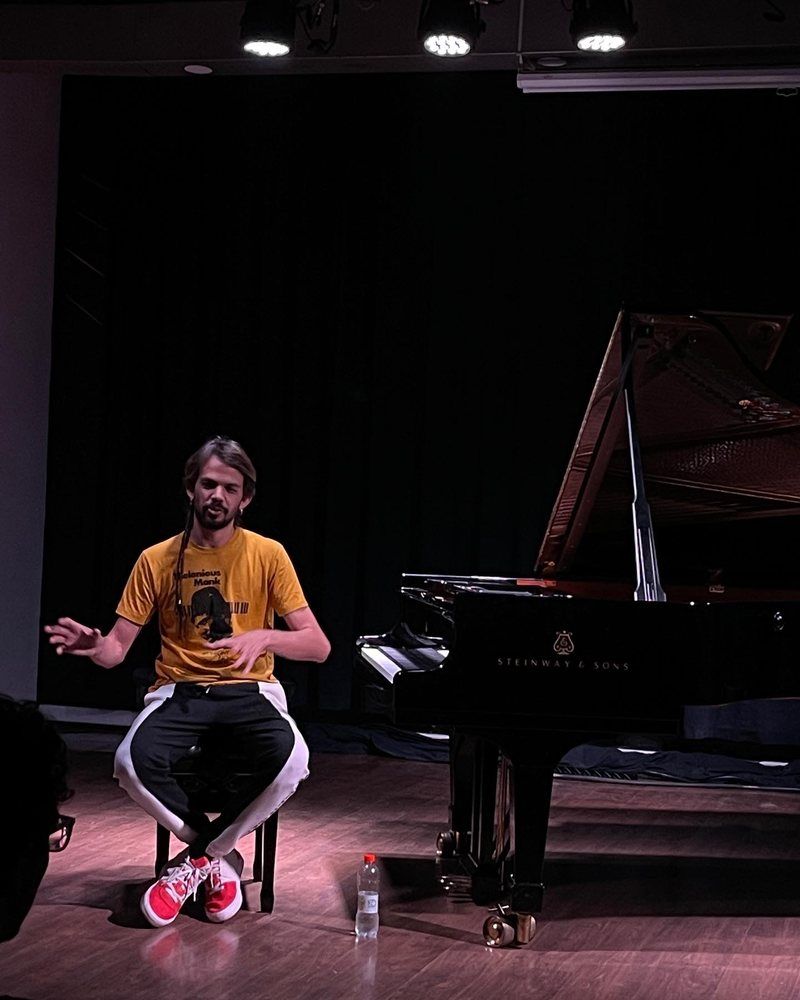 Salomão Soares conversando com a turma, ao lado do piano, numa masterclass
